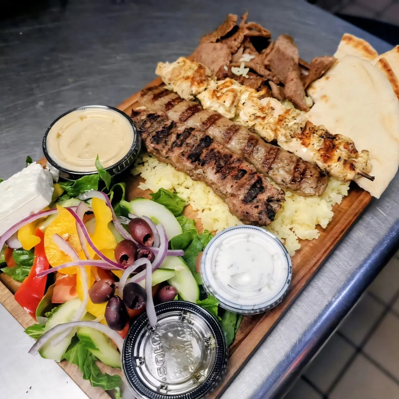 Taste of Greek’s platter of grilled kabobs, gyro meat, warm pita, rice, Greek salad, hummus, and tzatziki